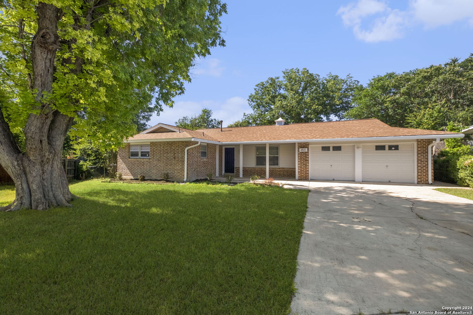 a front view of a house with a garden and yard