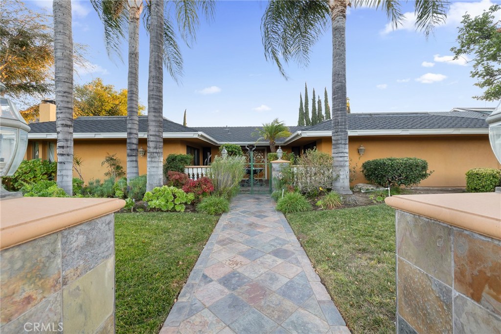 a front view of a house with a yard and potted plants