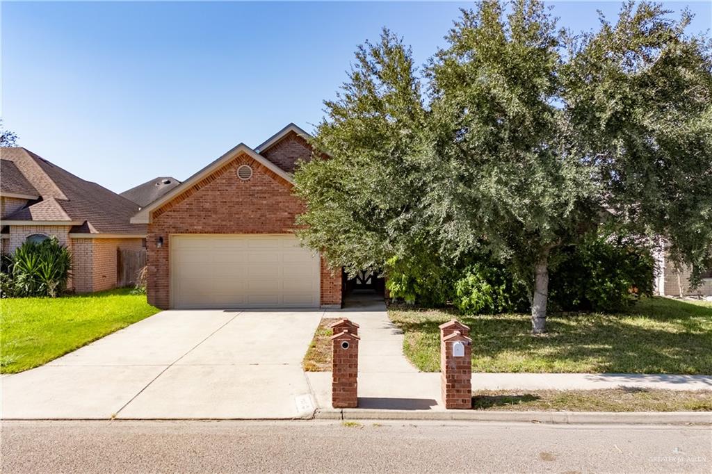 View of front of property with a garage and a front lawn