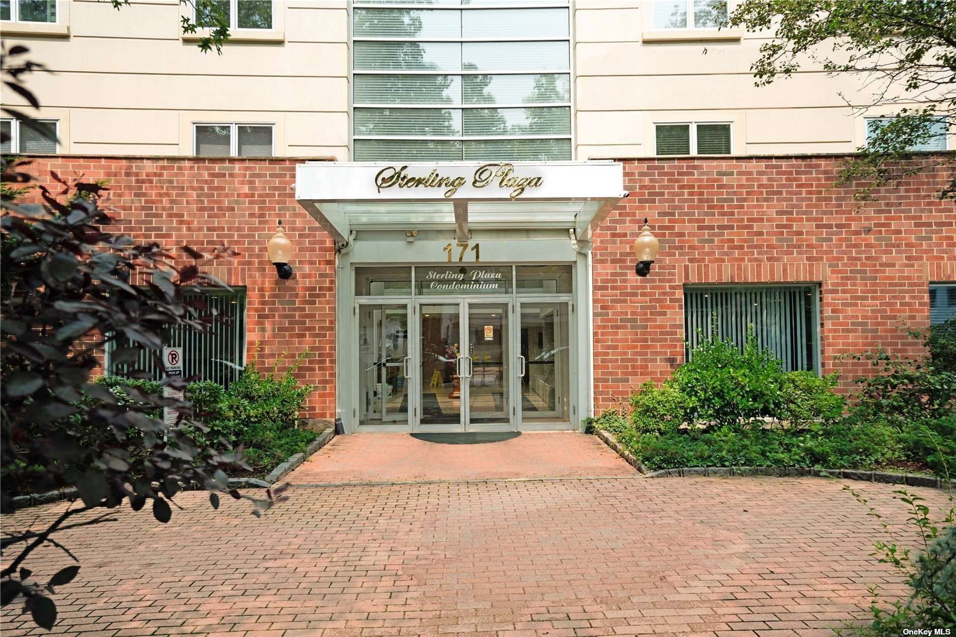 a front view of a building with a garden and plants