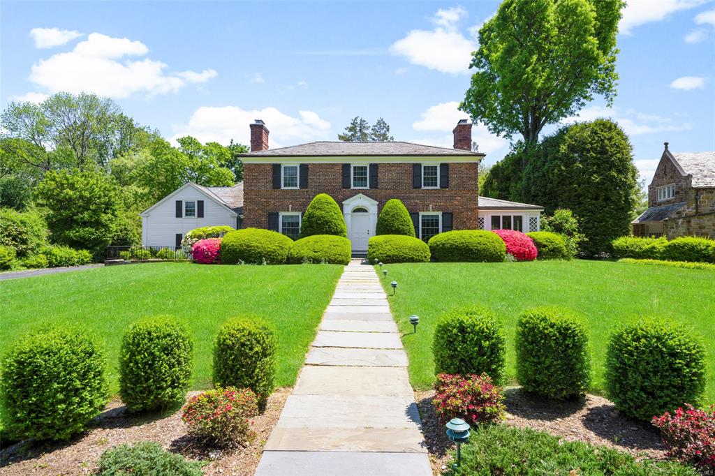 Colonial home with a front yard