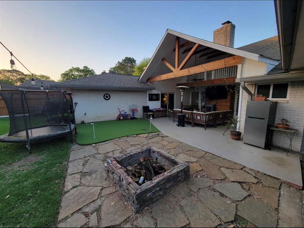 a view of a chair and table in backyard of the house