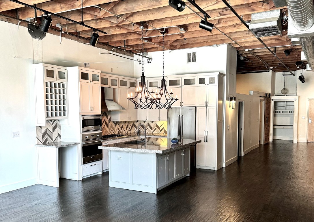 a view of a kitchen with stainless steel appliances granite countertop a stove and refrigerator