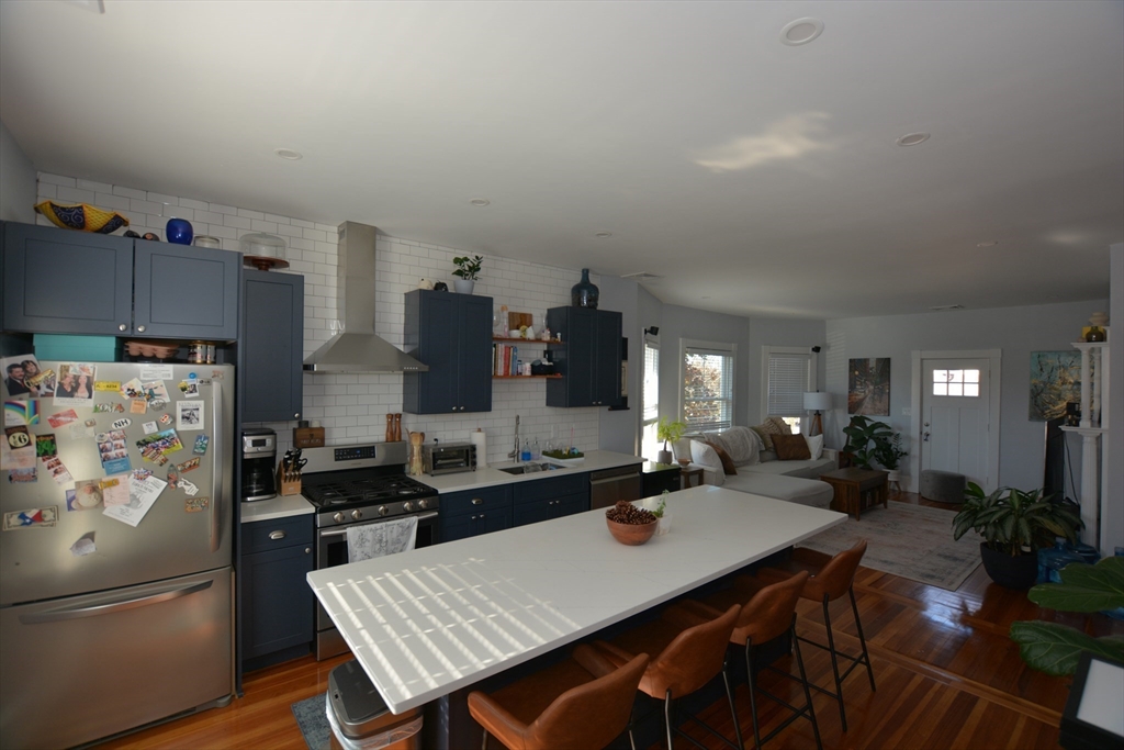 a kitchen with stainless steel appliances a table chairs and a refrigerator