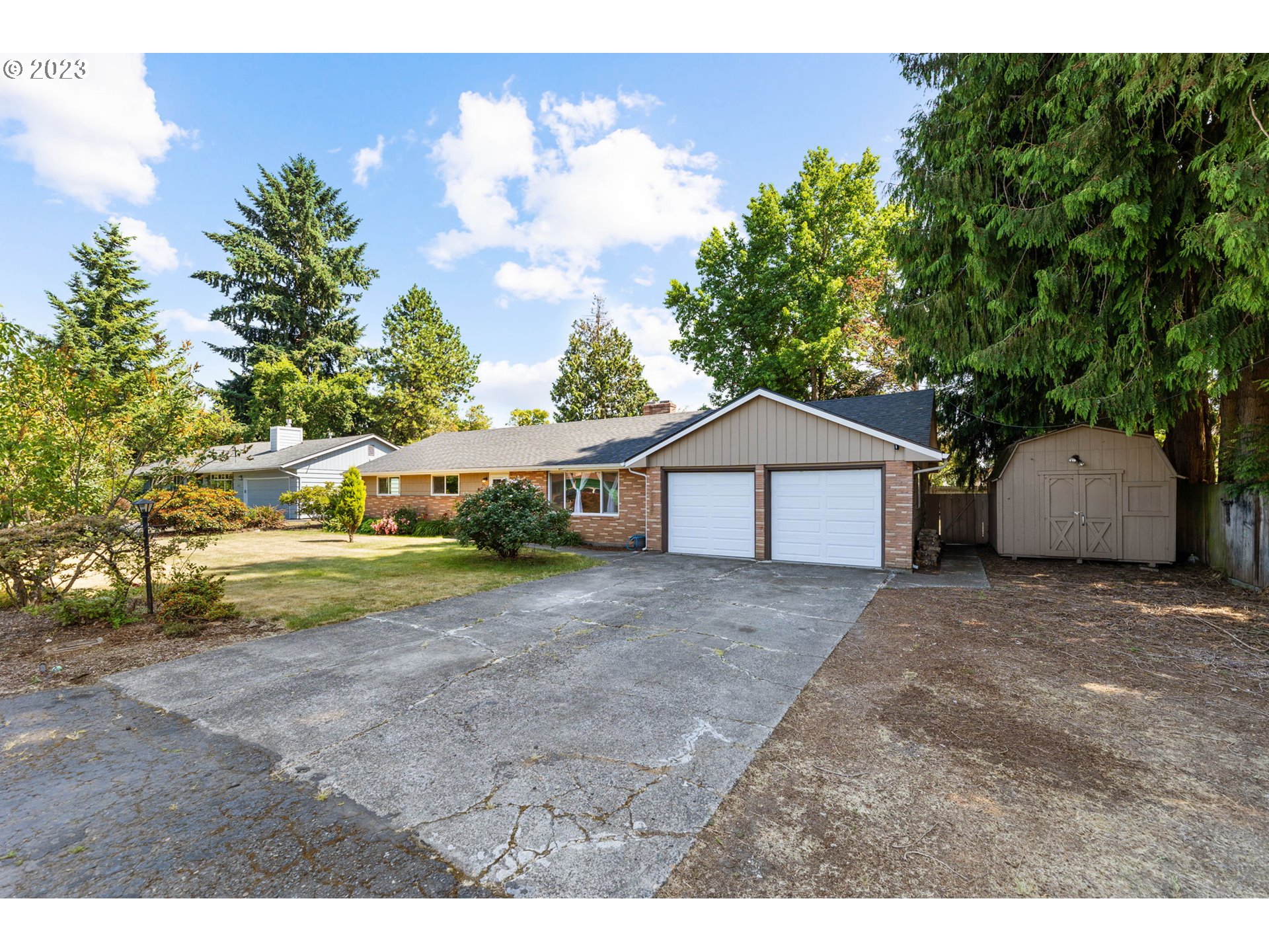 a view of a house with a yard and large tree