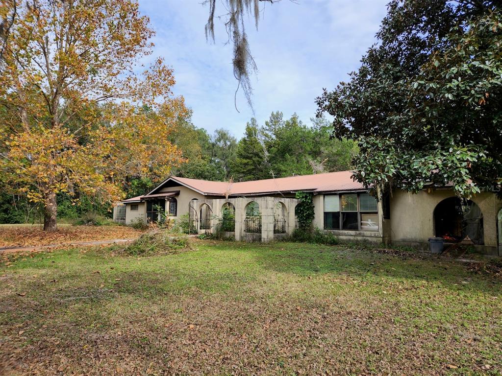 a view of a yard in front of a house with large tree