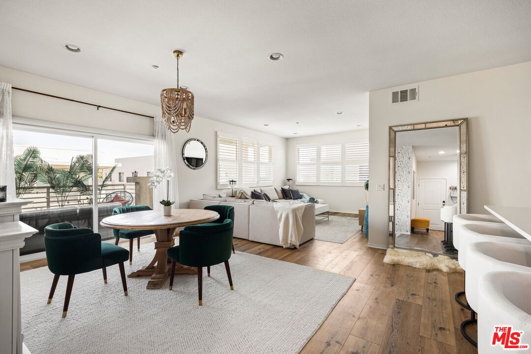 a living room with couches a coffee table and chairs with wooden floor