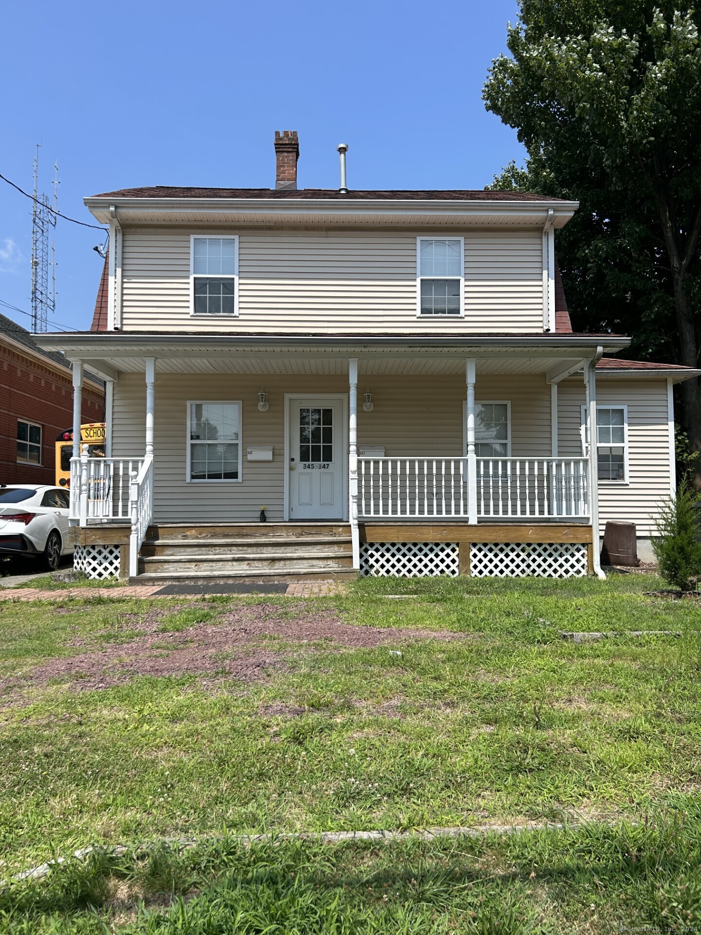 a view of a house with a patio and a yard