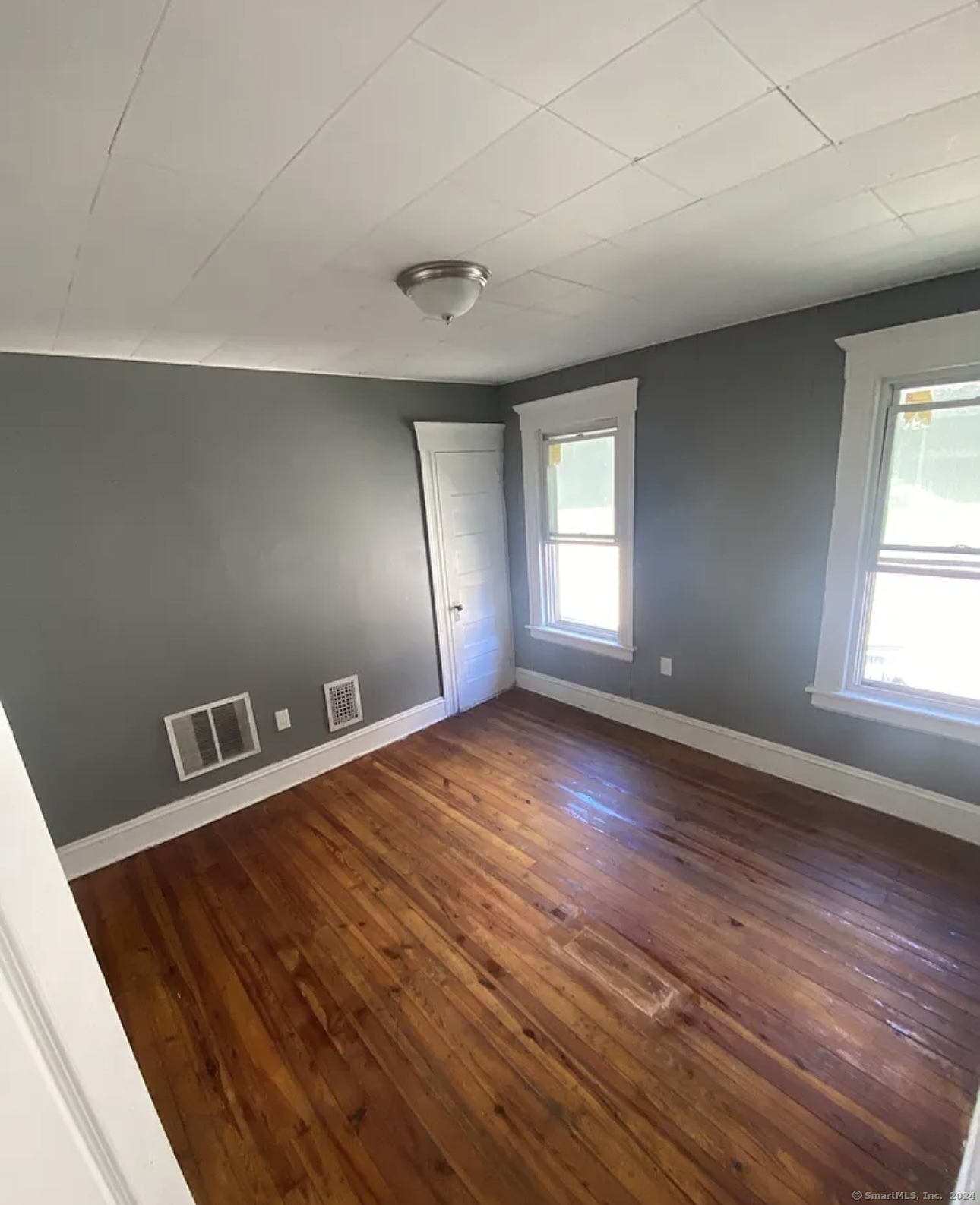 wooden floor in an empty room with a window