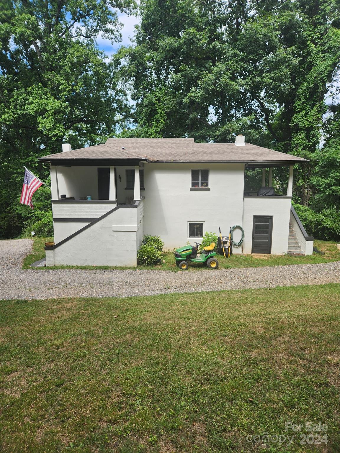 a front view of house with yard and trees in the background