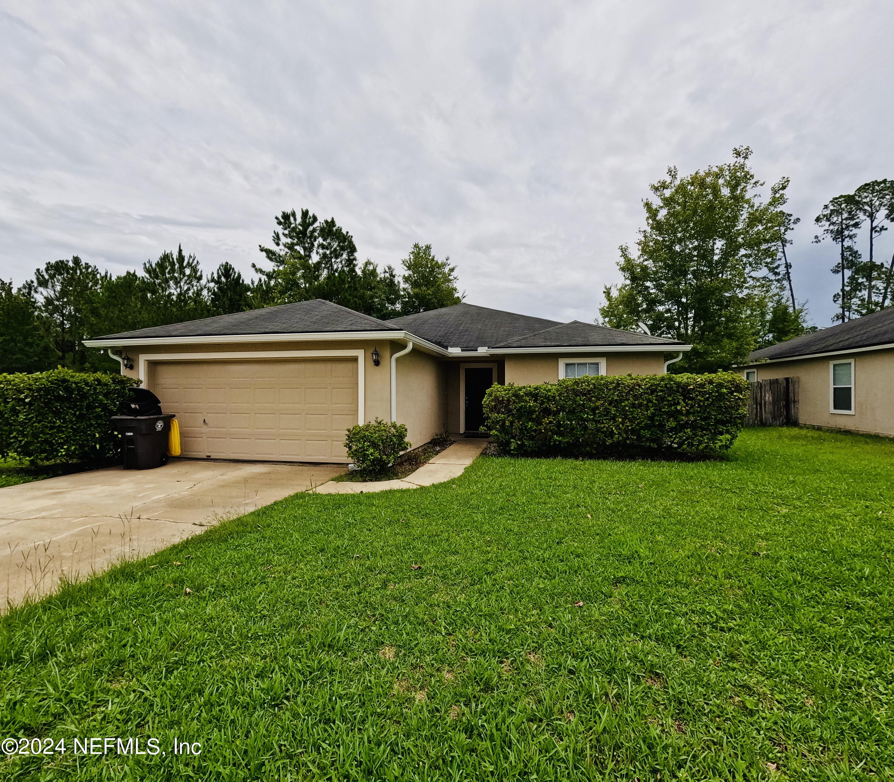 a front view of house with yard and green space