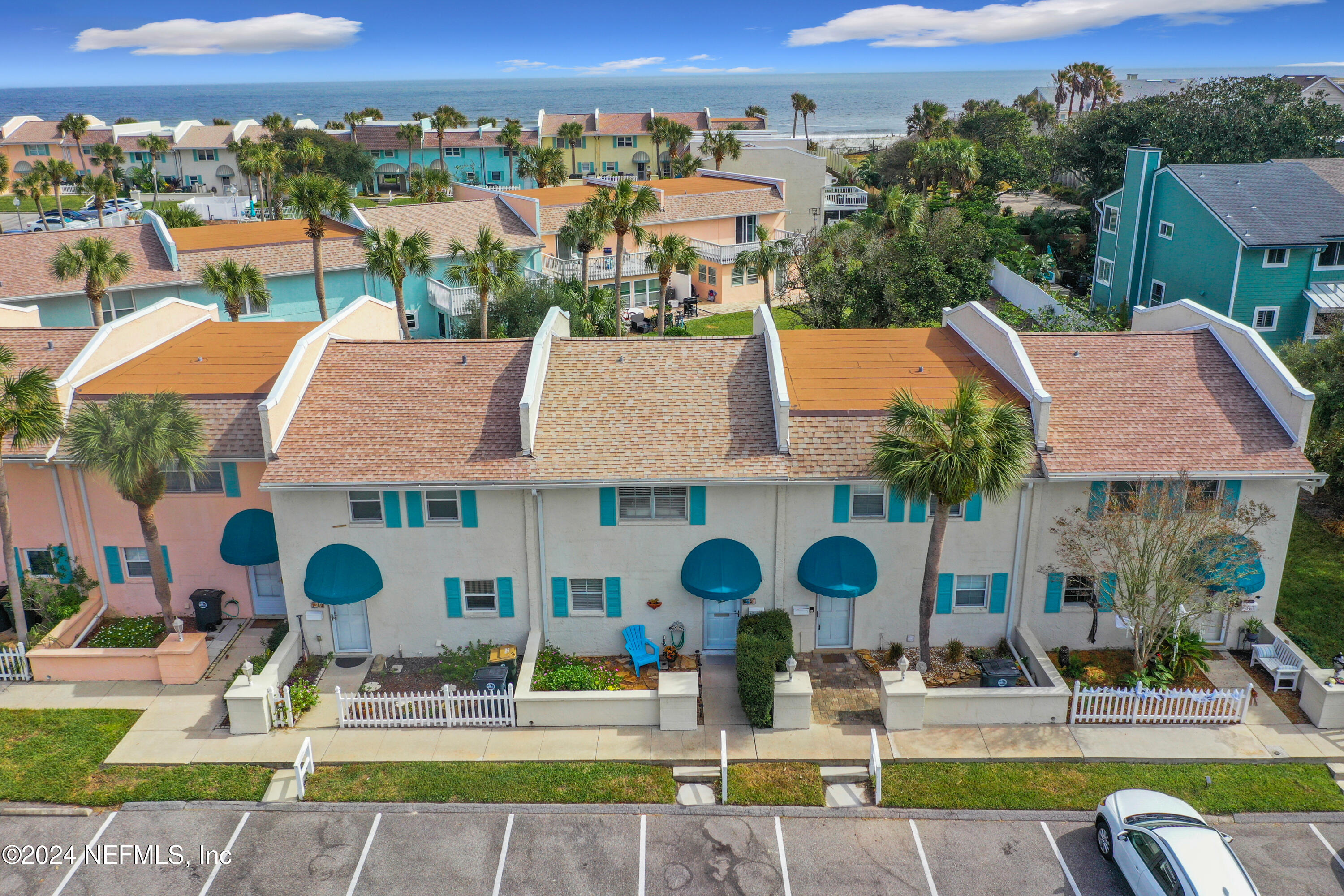 an aerial view of residential houses with outdoor space and parking