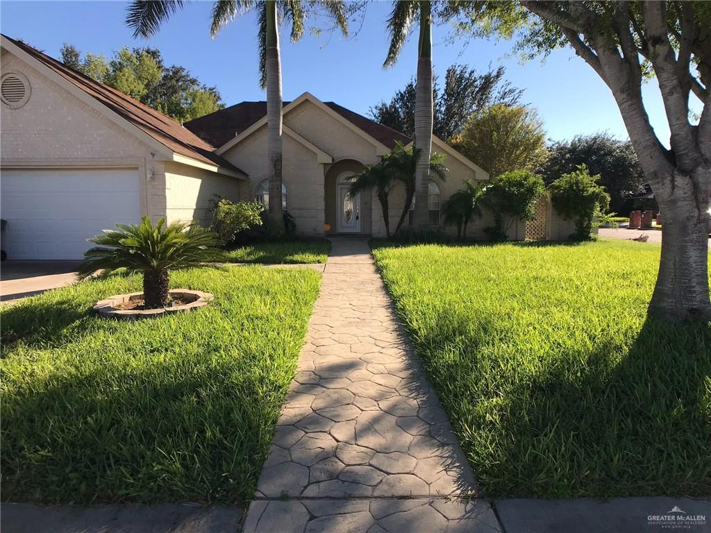 Single story home with a garage and a front lawn