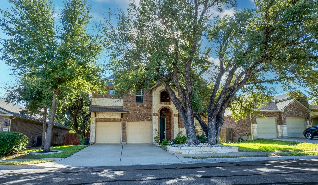 a front view of a house with yard and trees