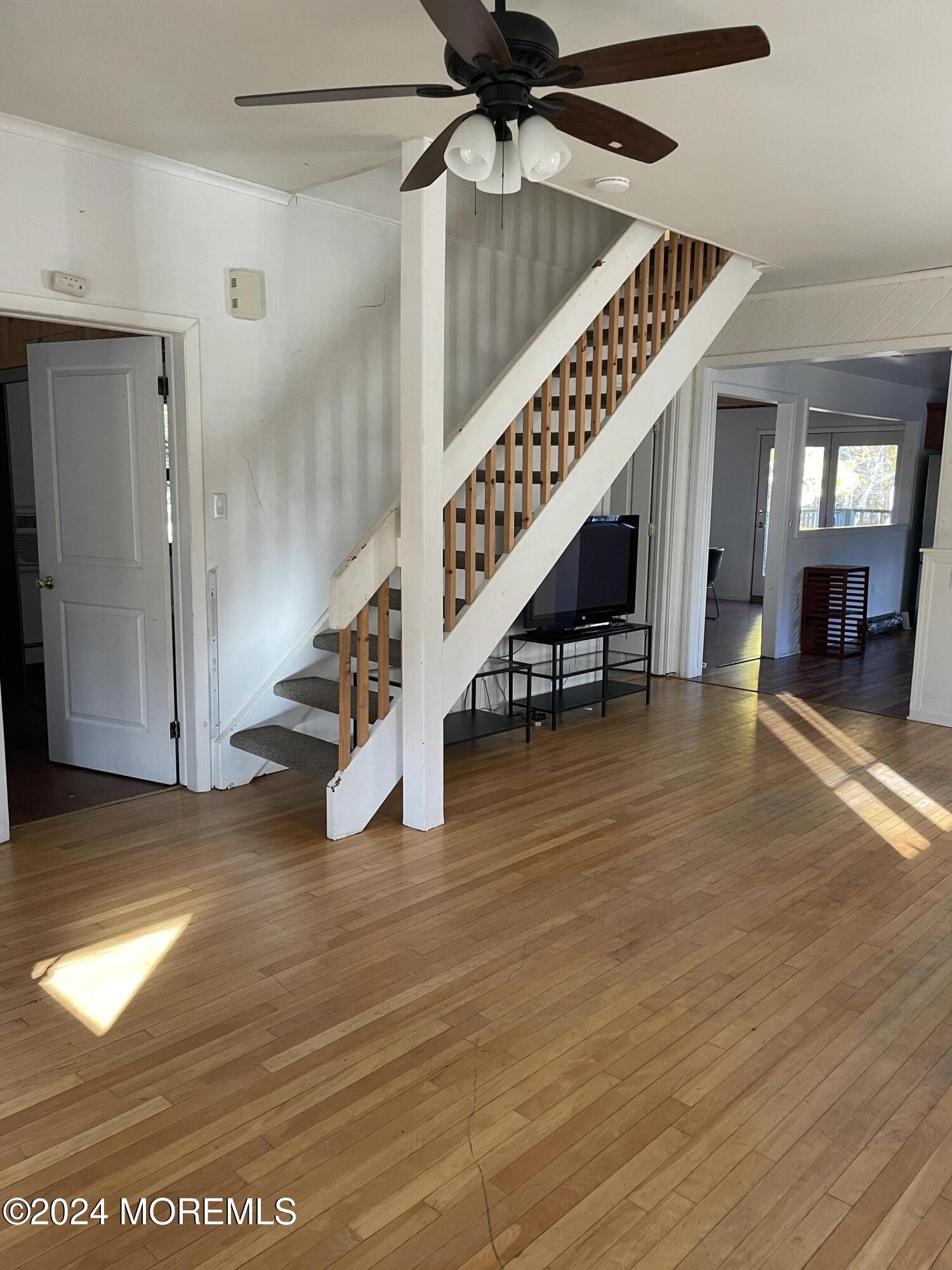 a view of entryway and hall with wooden floor