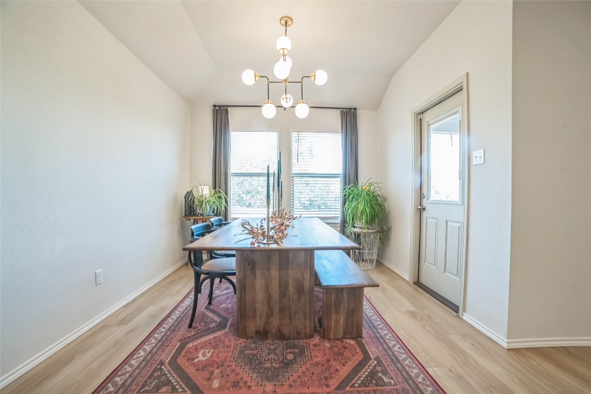 Dining Area with country views, wood-look flooring, updated light fixture and door to covered patio.