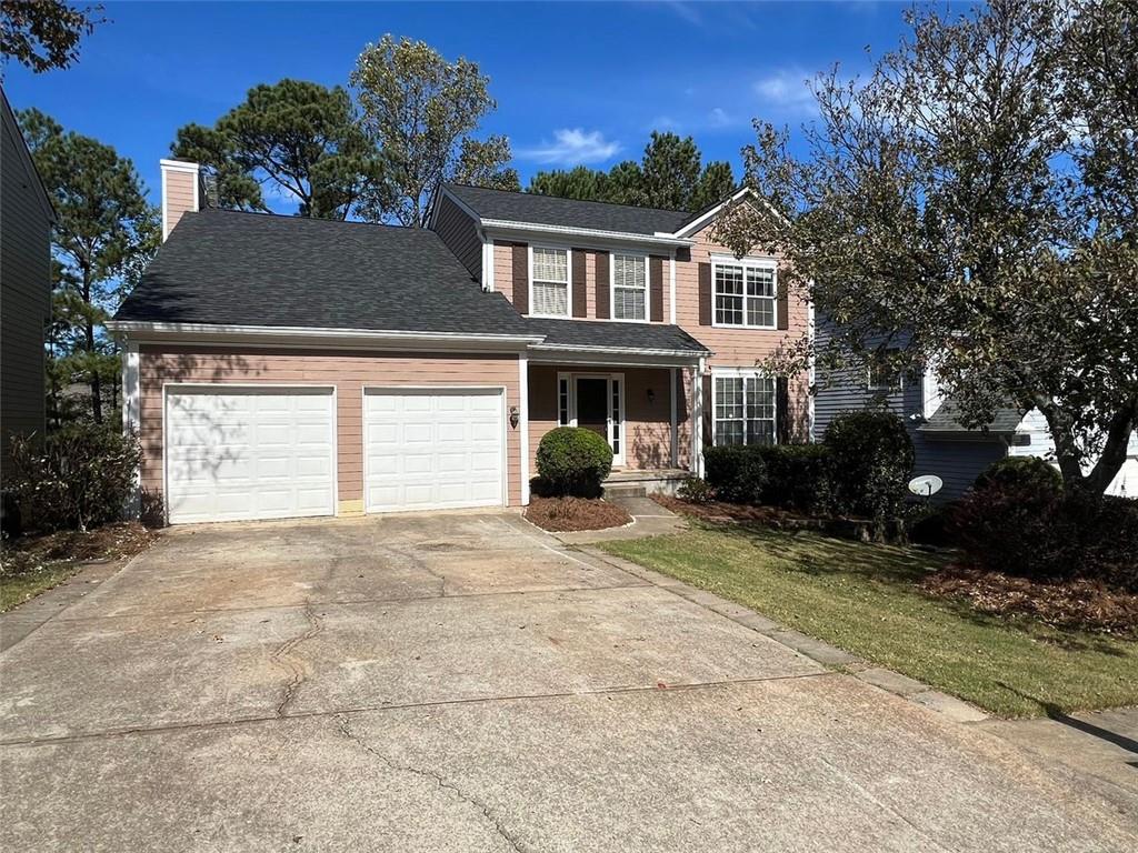 a view of a house with a yard and a garage