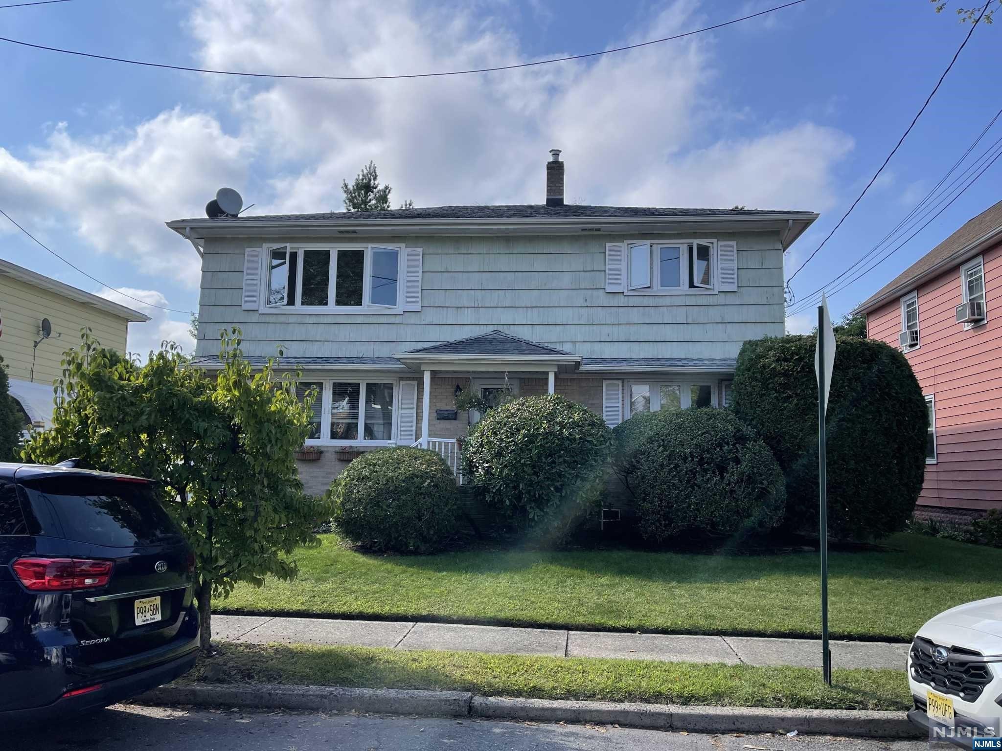 a front view of a house with a garden