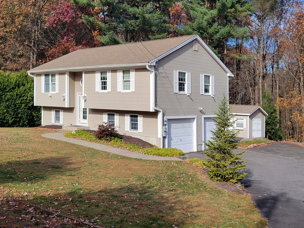 a view of a yard in front of a house with large trees