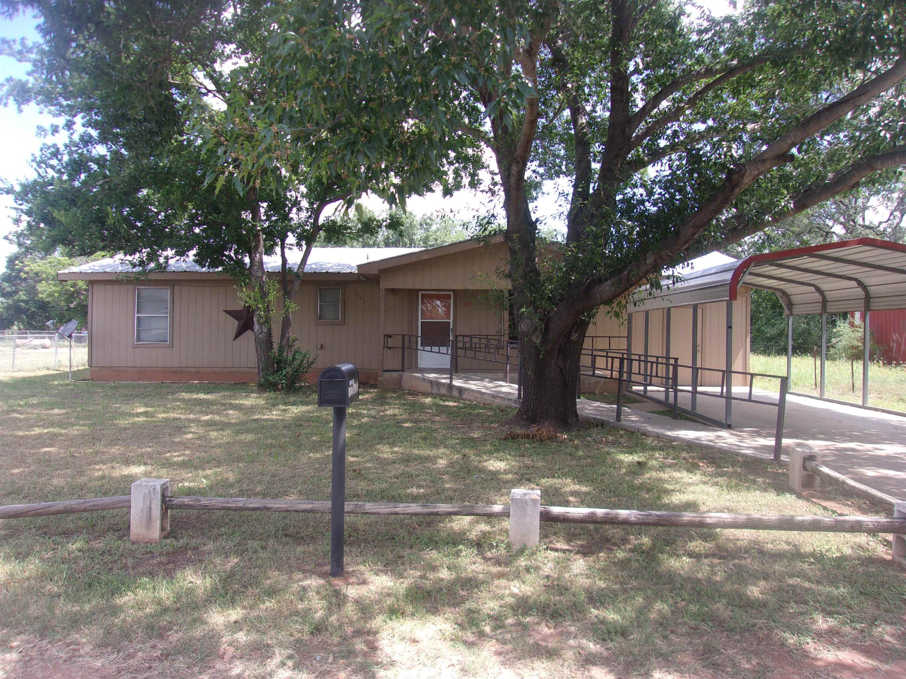 a view of a house with a tree in front of it