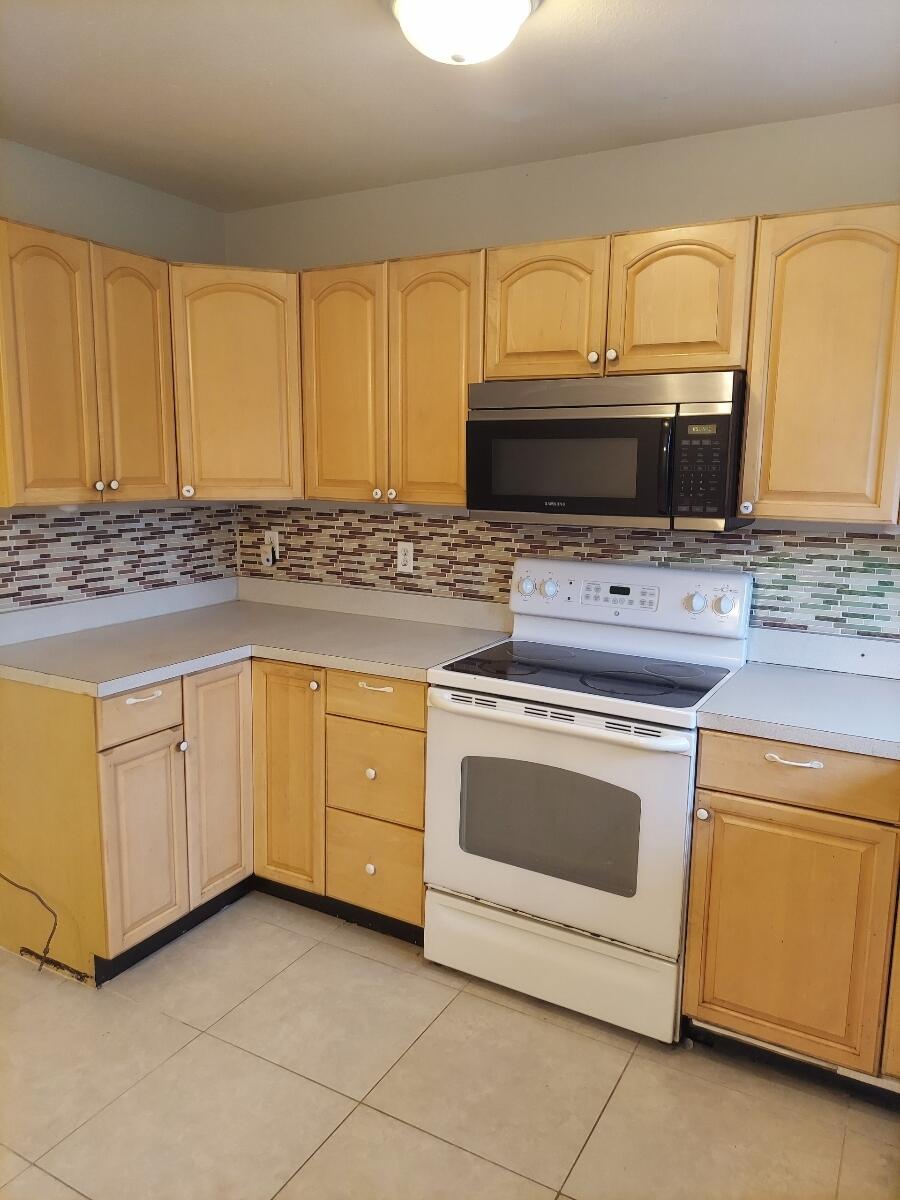 a kitchen with granite countertop white cabinets and stainless steel appliances