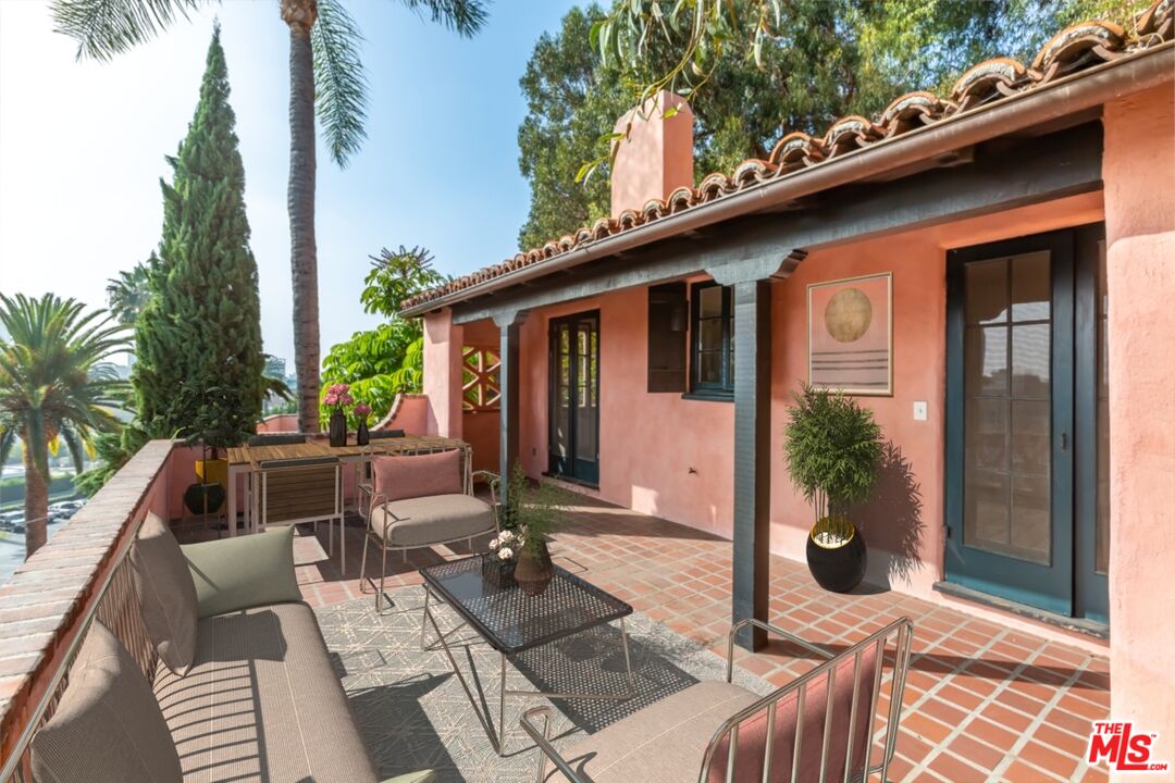 a view of backyard with outdoor seating and plants