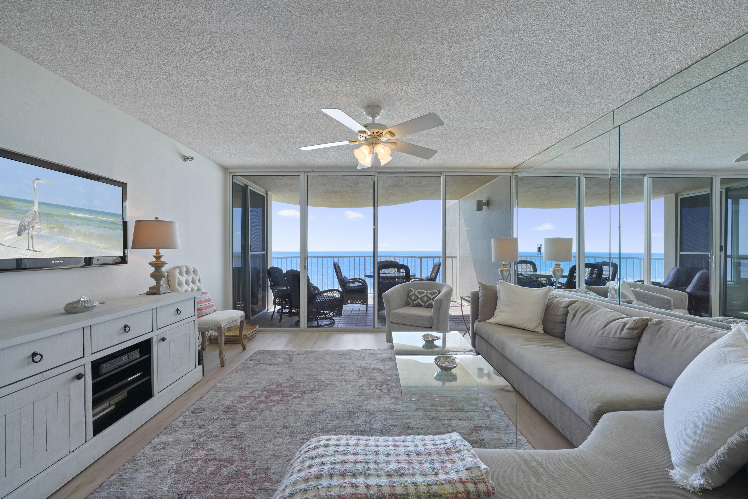 a living room with furniture kitchen view and a large window