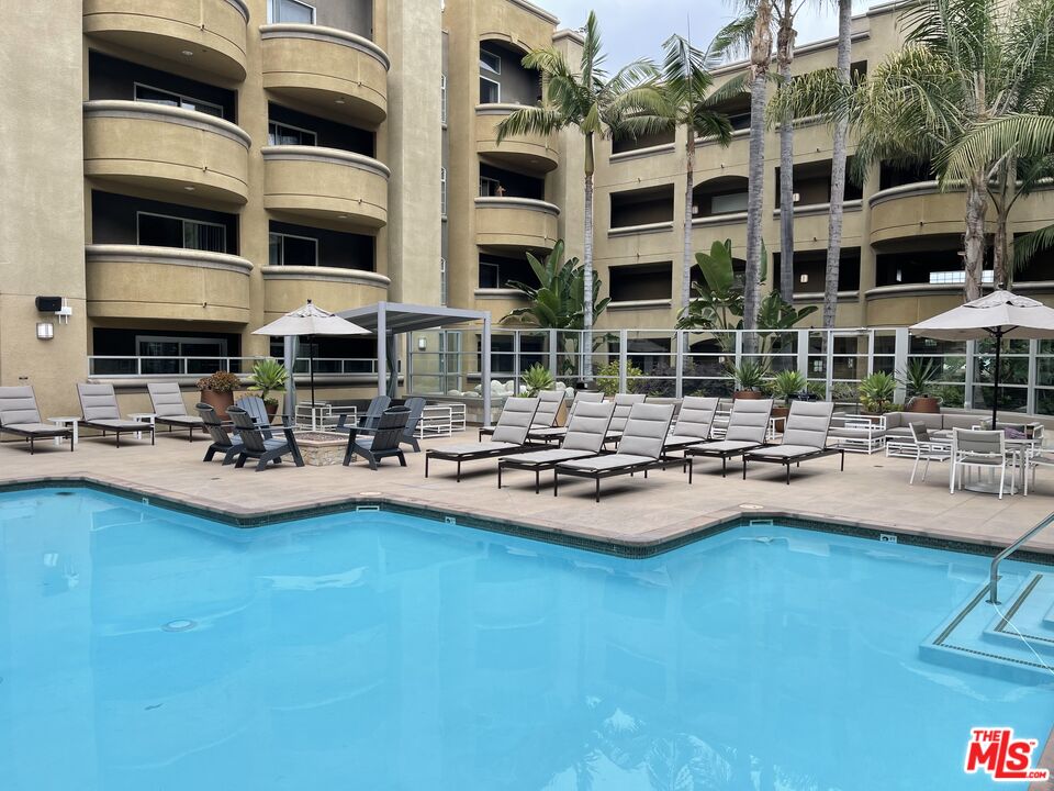 a view of pool with outdoor seating and house in the background