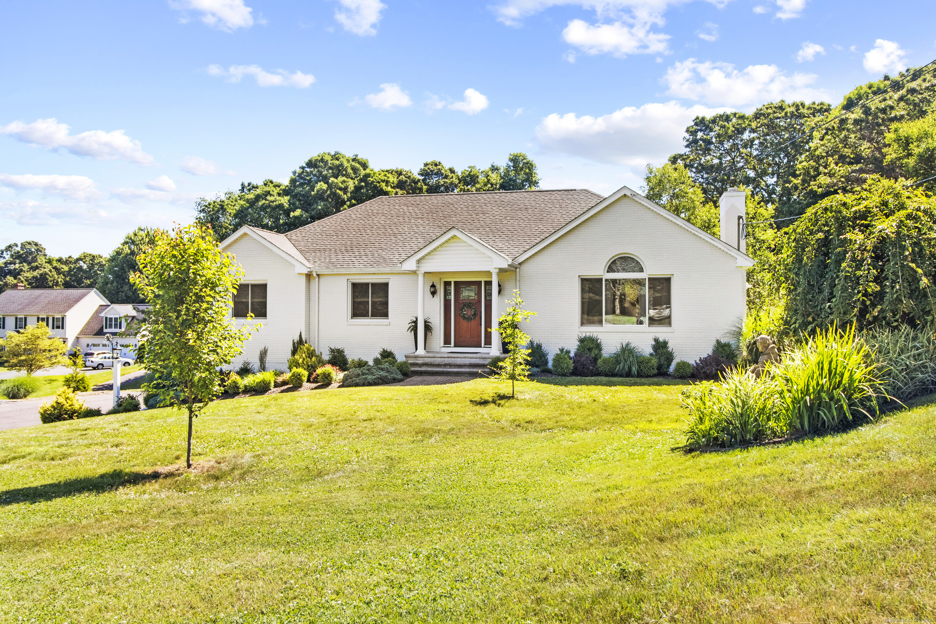 a view of a house with a yard and potted plants