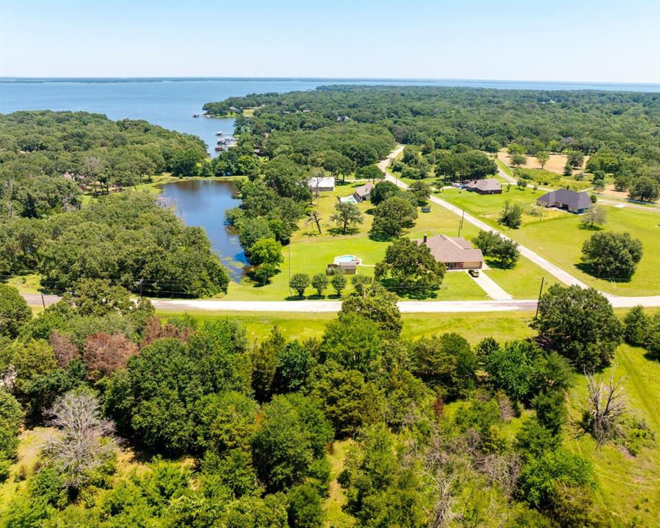 an aerial view of residential houses with outdoor space and trees all around