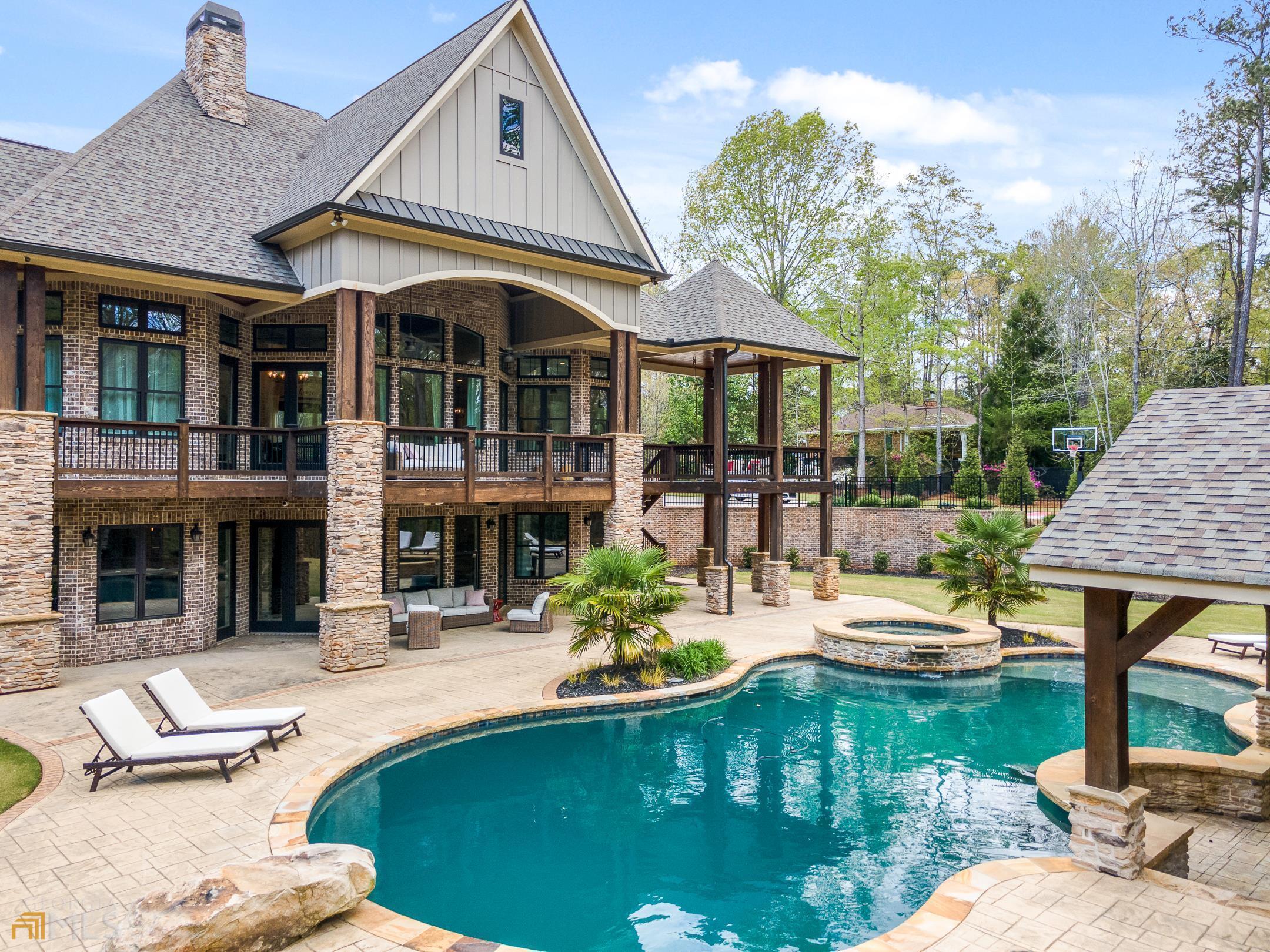 a swimming pool view with a seating space and a garden view