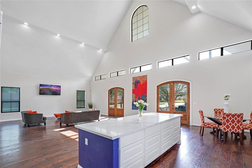 a living room with furniture kitchen view and a wooden floor