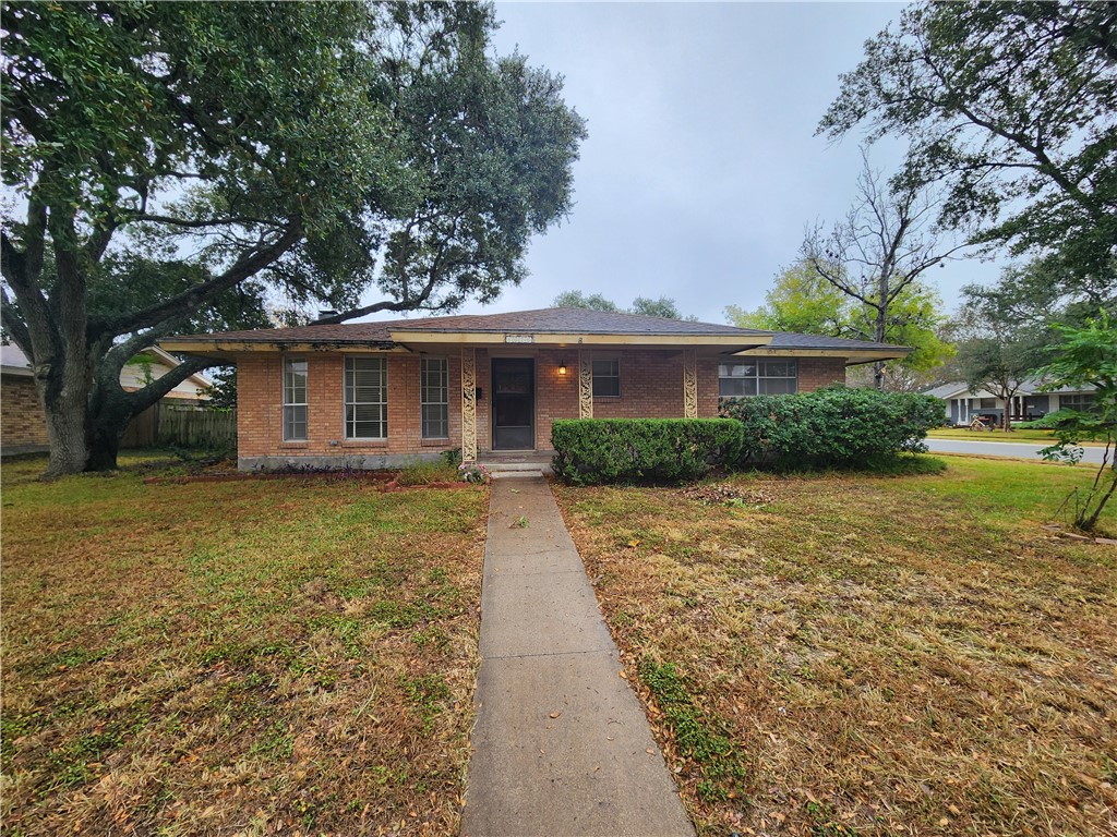 a front view of a house with a yard and trees