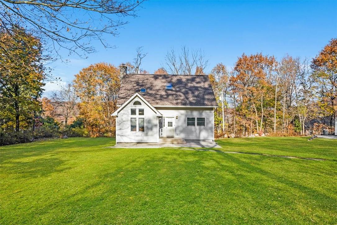 a view of a house next to a big yard and large trees