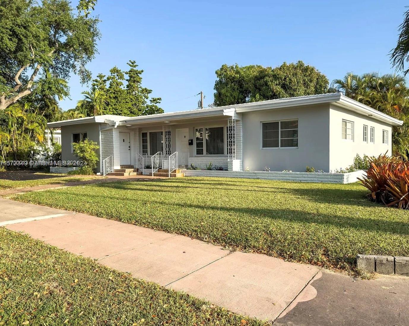 a front view of house with yard and green space