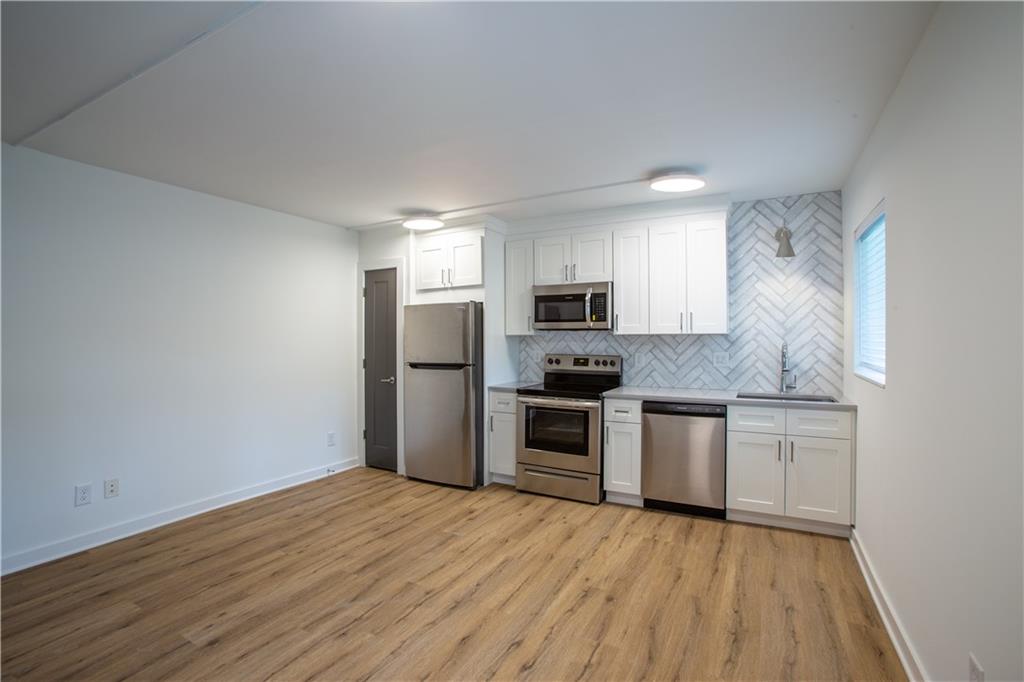 a kitchen with granite countertop a refrigerator stove and sink