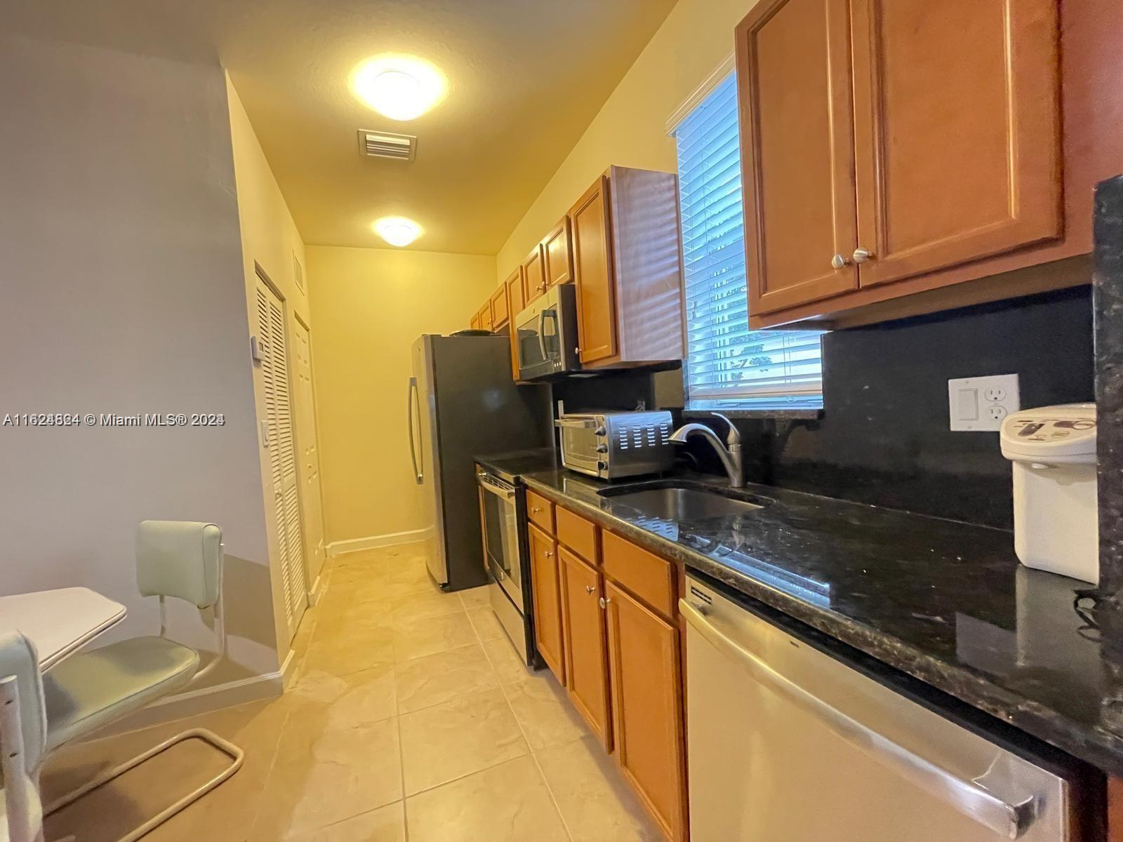 a kitchen with stainless steel appliances granite countertop a sink and cabinets