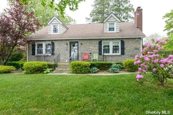 a front view of a house with a yard and trees