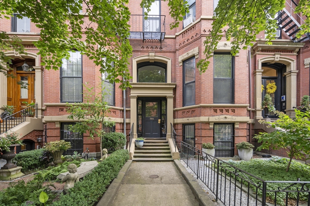 a view of a house with brick walls and a small yard