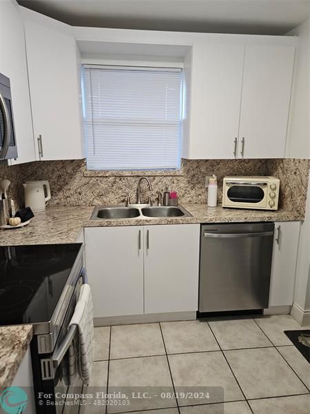 a kitchen with a stove a sink and a microwave