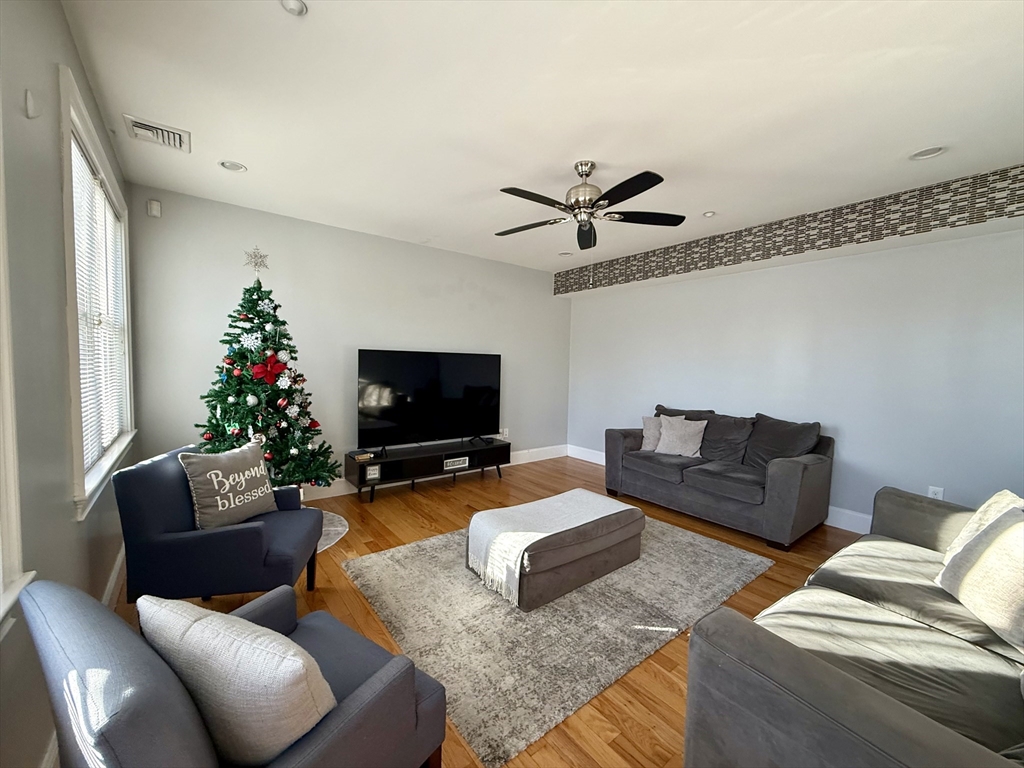 a living room with furniture a flat screen tv and a potted plant