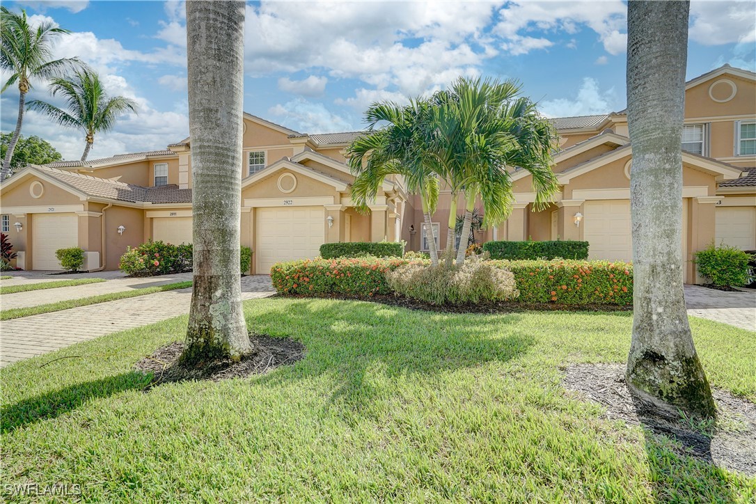 a front view of a house with a yard and potted plants