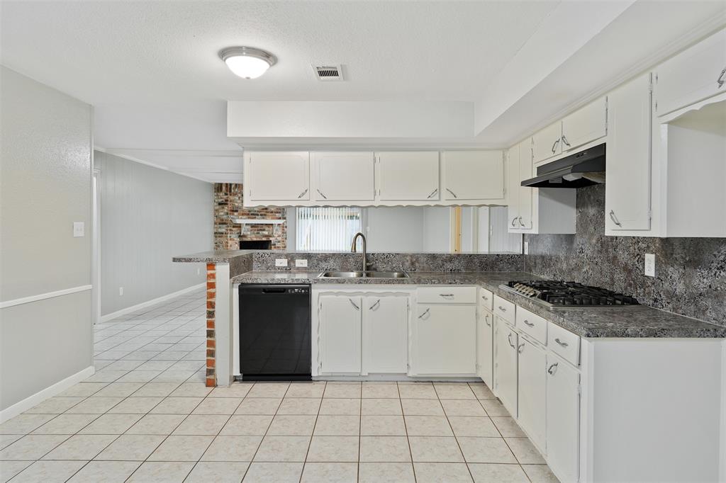 a kitchen with a stove sink and cabinets