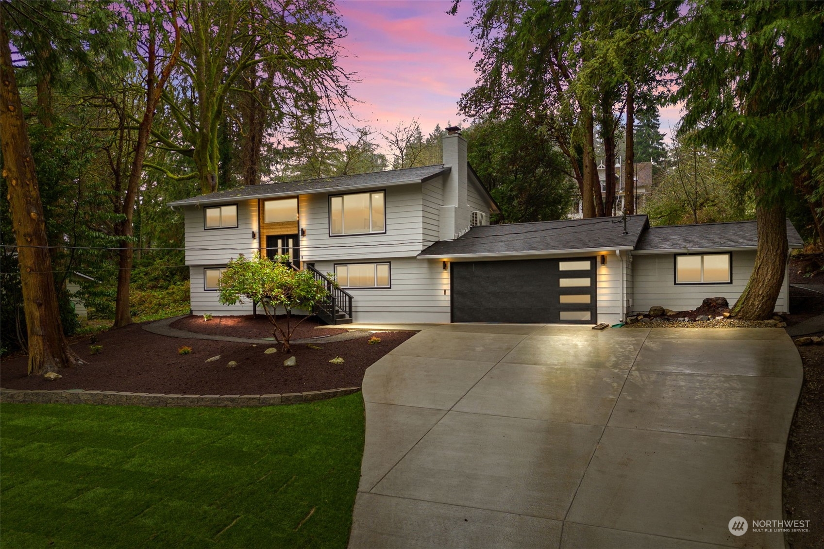 a front view of house with yard and trees in the background