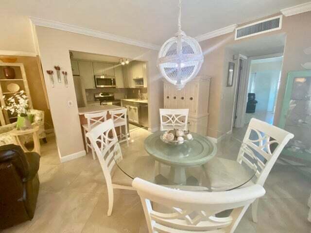 a dining room with wooden floor and kitchen view