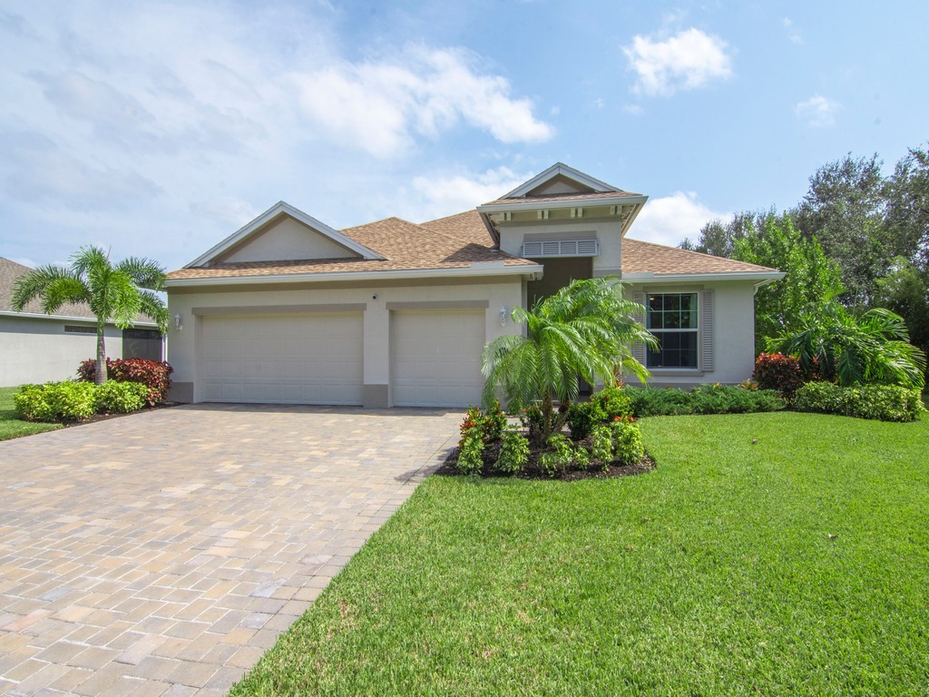 a front view of a house with a garden and yard