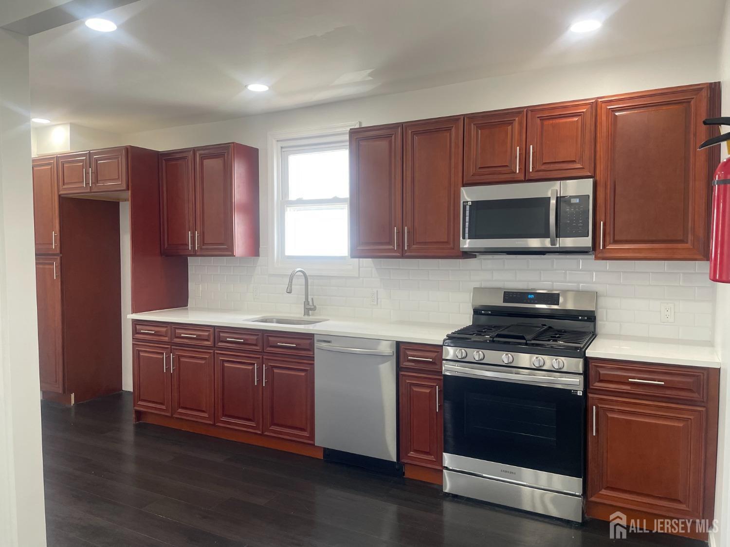 a kitchen with stainless steel appliances wooden cabinets and a stove top oven