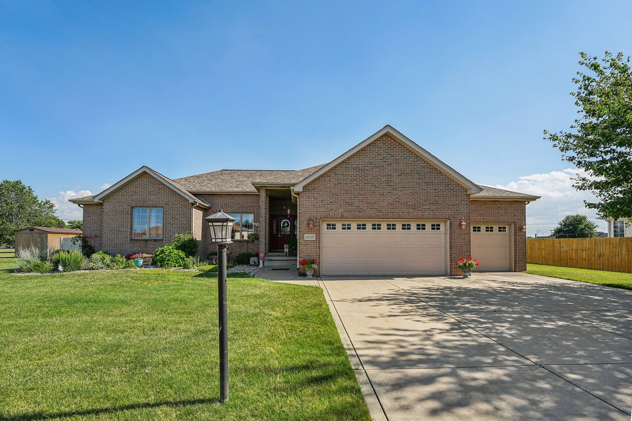 a front view of a house with yard and green space