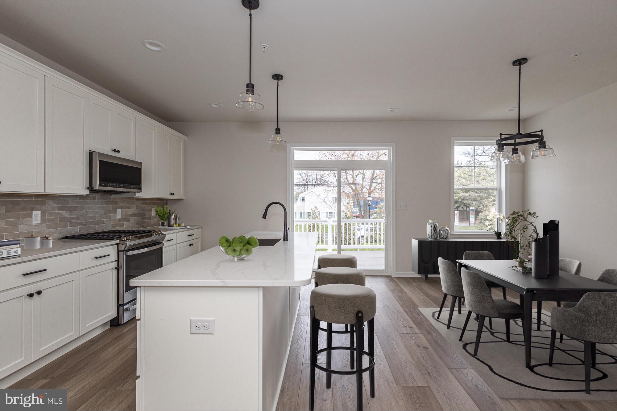 a kitchen with a stove a sink a dining table and chairs