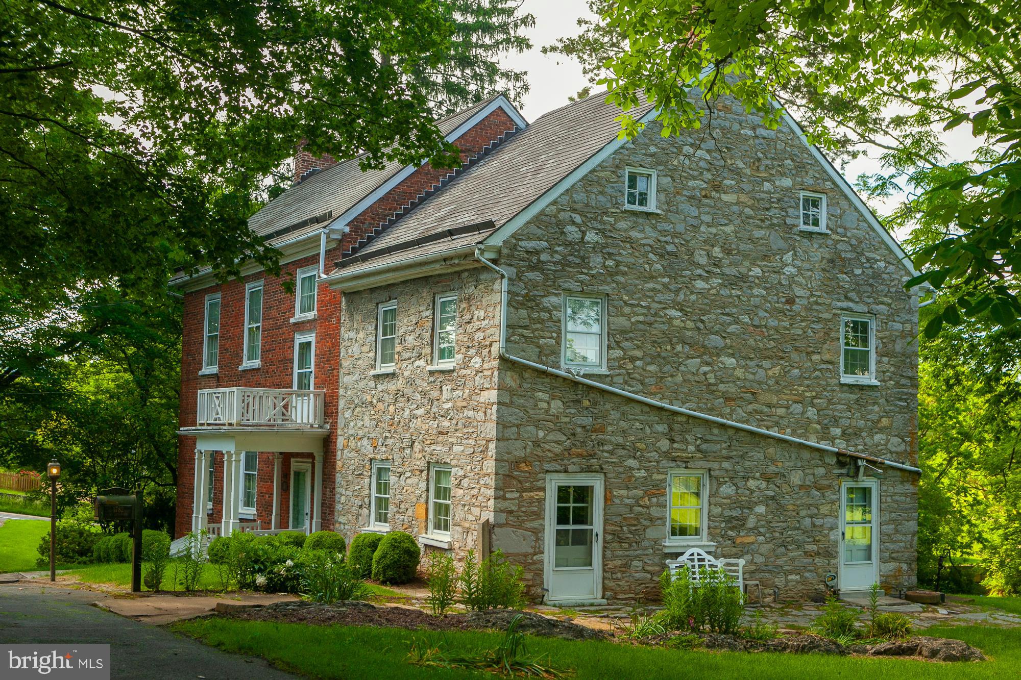 a brick house with trees in front of it